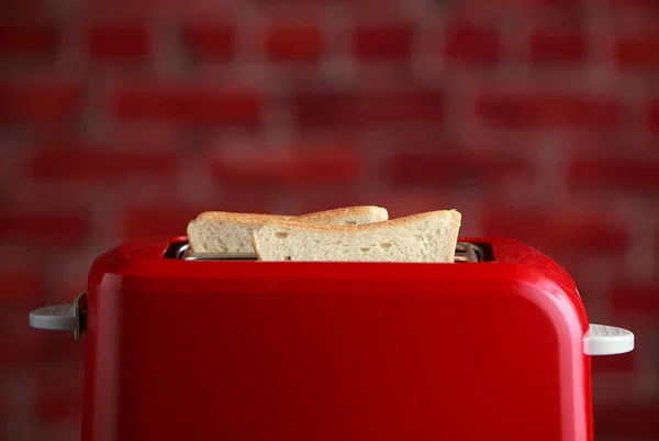 toaster with toasted sliced bread on bricks wall background. Kitchen equipment