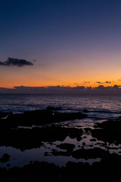 海の端の潮溜まりの上のカラフルな夕日の空の三日月 — ストック写真