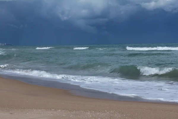 濃い青の水で砂浜の上の風景青い嵐の雲 — ストック写真