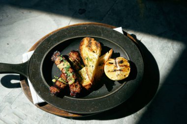 Sosis, tost ve limon güneşin altında dökme demir bir tabakta..