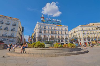 Puerta del Sol, Madrid, İspanya; 16 Eylül 2018: Puerta del Sol 'daki meydanın görüntüsü, dükkanlar, yürüyen insanlar ve ön planda bir çeşme ve arka planda Madrid, İspanya' daki diğer caddelere bakan binalar.