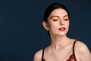 Koyu mavi arka planda şehvetli, nazik bir esmer.