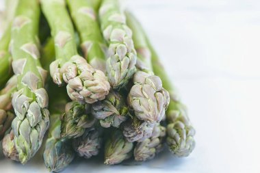 Mermer arka planda bir demet taze kuşkonmaz..