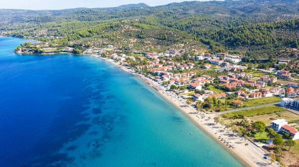 Aerial sunset view of amazing Neos Marmaras cityscape and distant turtle island in Greece.