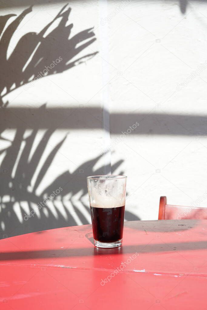 A half pint of Guinness outside on a table.