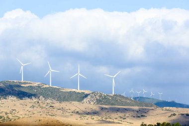 Akdeniz 'de yel değirmenleri ve dev bulutları olan Mountainside.
