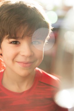 Güneşli tavşanlı, kırmızı tişörtlü sevimli bir çocuğun portresi.