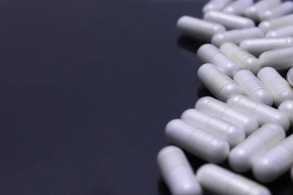 Αρκετά Λευκά Χάπια Ομαδοποιούνται Μια Μαύρη Επιφάνεια — Φωτογραφία Αρχείου