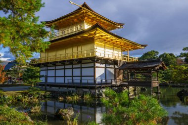 Kinkakuji Zen Budist Tapınağı, emeklilik kompleksi olarak bilinen büyük bir gölete bakan etkileyici bir yapıdır. Rokuonji resmi adı. Kuzey Kyoto 'nun en manzaralı, nefes kesici ve tarihi sürücülerinden biri, baş döndürücü arşiv.
