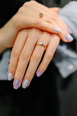 Parmağında elmas bir yüzük olan tanınmayan genç bir kadın.