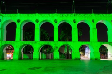 Brezilya 'nın Rio de Janeiro şehrinde gece vakti yeşil ışık alan eski beyaz su kemerine güzel bir manzara