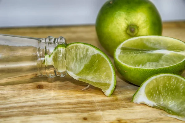 Limefrukter Och Flaskhals Träskiva — Stockfoto