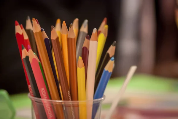 Colored pencils, a jar full of colored crayons to draw and color