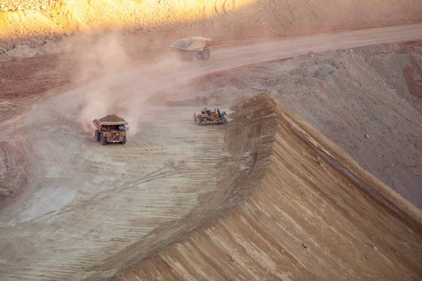 Dump trucks stir up dust hauling dirt mining Morenci, Arizona