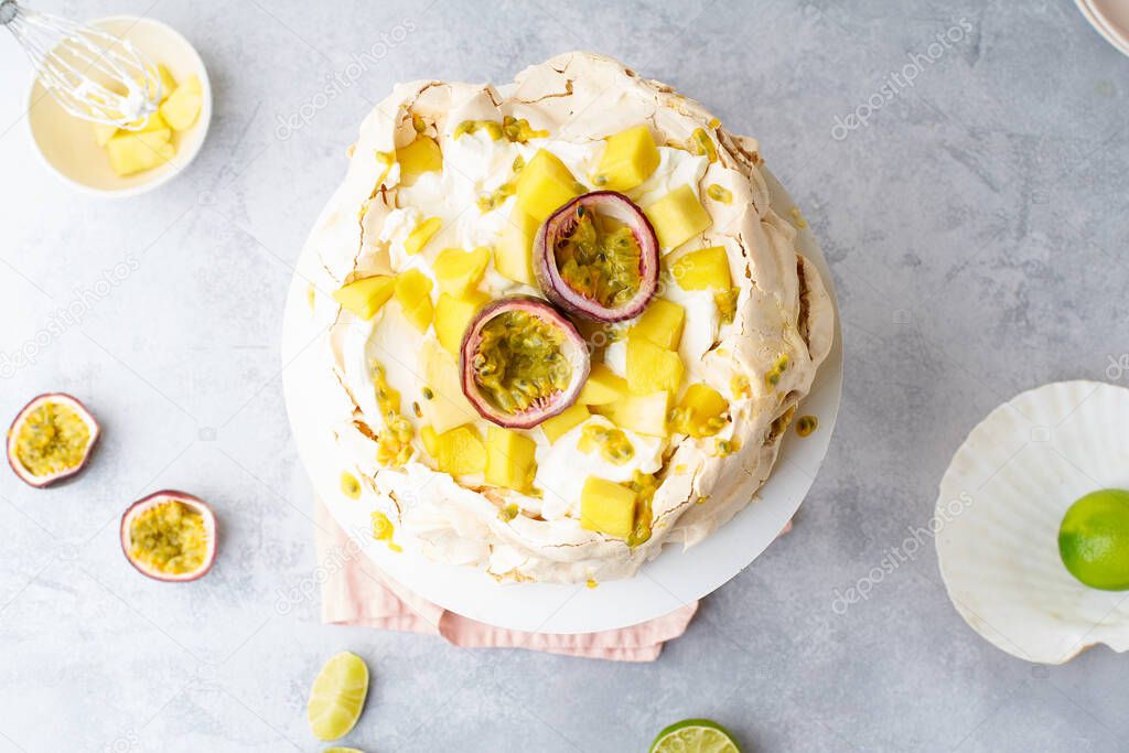 Pavlova cake with passion fruit, mango, lime and banana cream