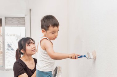 Anne ve oğlu duvarı birlikte boyuyor. Anne ve çocuk eğlence zamanı..