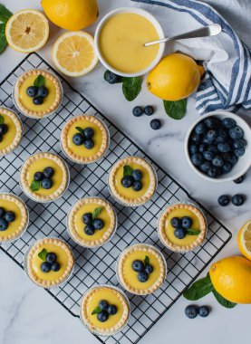 Mermer tezgahta yaban mersinli mini limonlu turta manzarası.