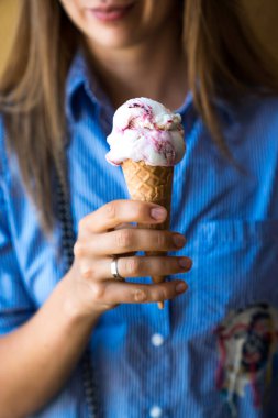 Kadının eli buzlu mısırı tutuyor. Kapat.