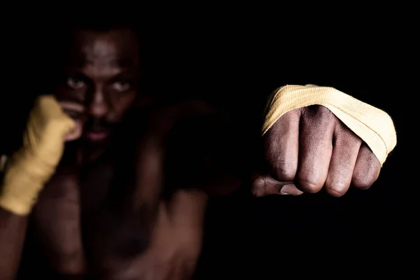 Africano Homem Com Bandagens Boxer Dando Golpe Direto Fundo Preto — Fotografia de Stock