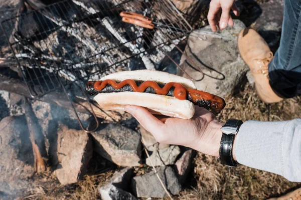 Person Holding Hot Dog Outdoor Fire Whilst Camping — Zdjęcie stockowe