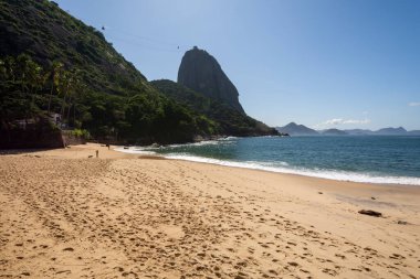 Güneşli bir günde, Rio de Janeiro, Brezilya 'daki Covid-19 salgını sırasında boş bir sahilden Sugar Loaf Dağı' na güzel bir manzara