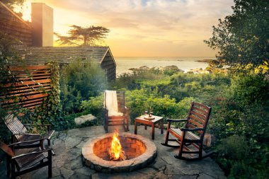 Outdoor fireplace by cabin and ocean clipart