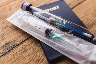 syringe, passport  and test swab  on wooden  background.