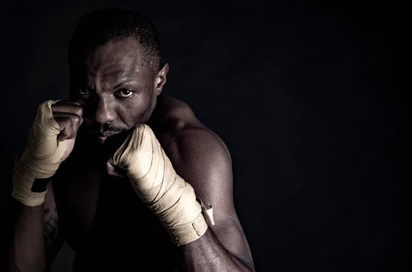 非洲男子与拳击绷带 给予直接命中 黑色背景 — 图库照片