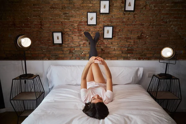 Wanita Muda Melihat Ponsel Saat Berbaring Tempat Tidur Rumah — Stok Foto