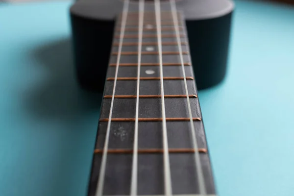 亮蓝色背景 简约主义风格 下明亮的黑色Ukulele吉他的身体 复制文本空间 — 图库照片