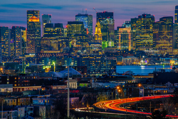 Boston city buildings and light trails during blue hour.