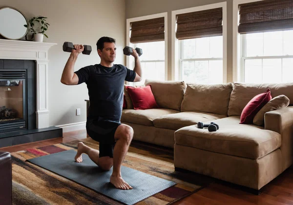 适合男人在客厅里用手举重在家里锻炼 — 图库照片