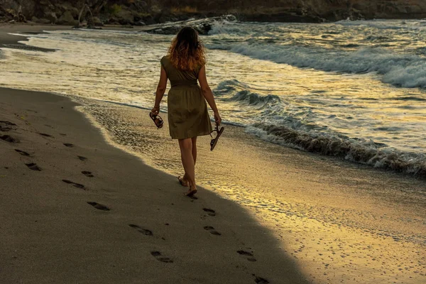 日落时分 妇女在沙滩上散步 在沙滩上留下脚印 — 图库照片
