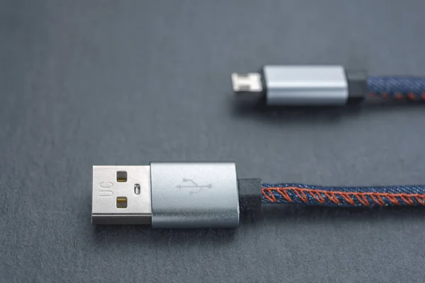 Micro USB cable with cable against a dark background..