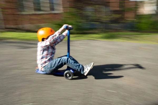 Jongen Buiten Draagt Oranje Helm Snelheden Oprit Blauwe Scooter — Stockfoto