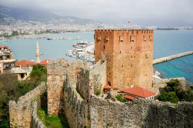 Kule (Kırmızı sekizgen kule) ve arka planda Alanya körfezi