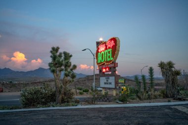 Yol kenarında büyük bir neon otel tabelası.
