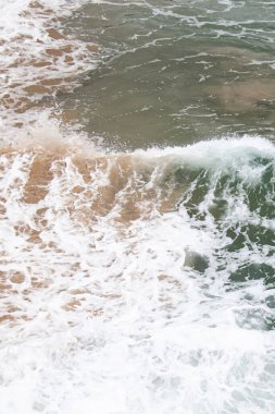 Bir dalganın köpüğü başka bir dalgaya karşı kırılıyor