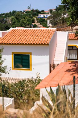 Beyaz duvarları, sarı sınırları ve fayanslı çatıları olan Portekiz evi..