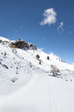 Arkasında dağ olan karlı bir yol.
