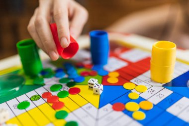 Woman Hand throwing two dices playing Parcheesi, Parchis game board