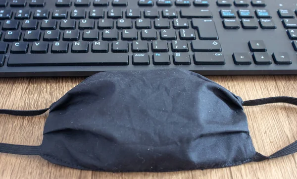 Maske Neben Einer Bürotastatur Auf Einem Schreibtisch Als Neuer Tagesgegenstand — Stockfoto