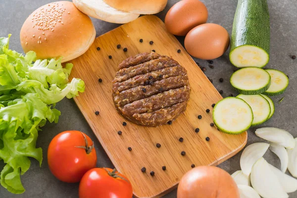 burger ingredients arranged on wooden plate