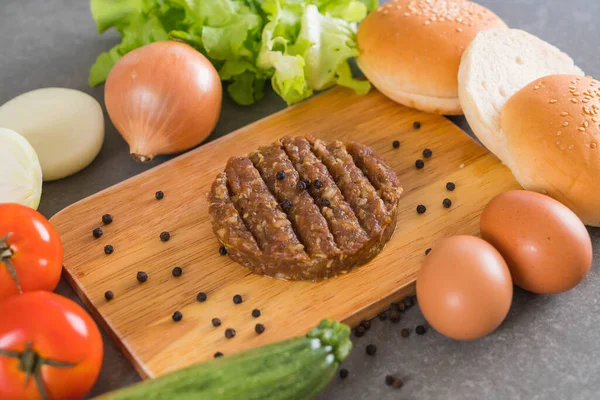 burger ingredients arranged on wooden plate
