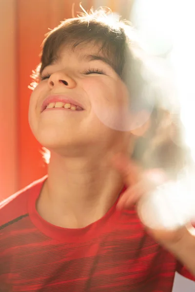 Portret Uroczego Chłopca Czerwonej Koszulce Promieniami Słońca Słonecznymi Króliczkami — Zdjęcie stockowe