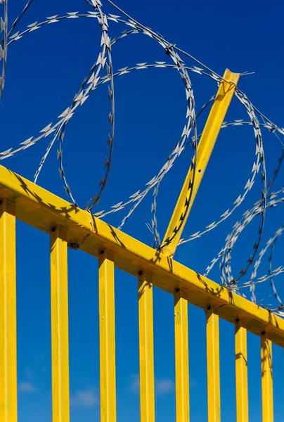 Razor Wire Bright Yellow Metal Barrier Deep Blue Sky — Stock Photo, Image