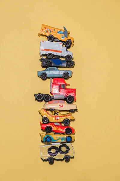 Carros Brinquedo Empilhados Uns Cima Dos Outros Fundo Amarelo — Fotografia de Stock