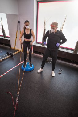 Genç bayan eğitmenle kişisel eğitim yapıyor.