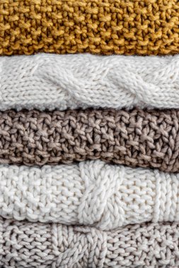 Sandalyenin üzerine yün örülmüş ekose kumaşlar örülmüş.