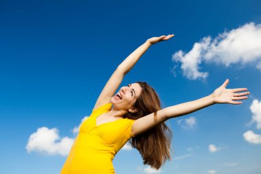 Outdoor portrait of a beautiful and happy woman on sky background